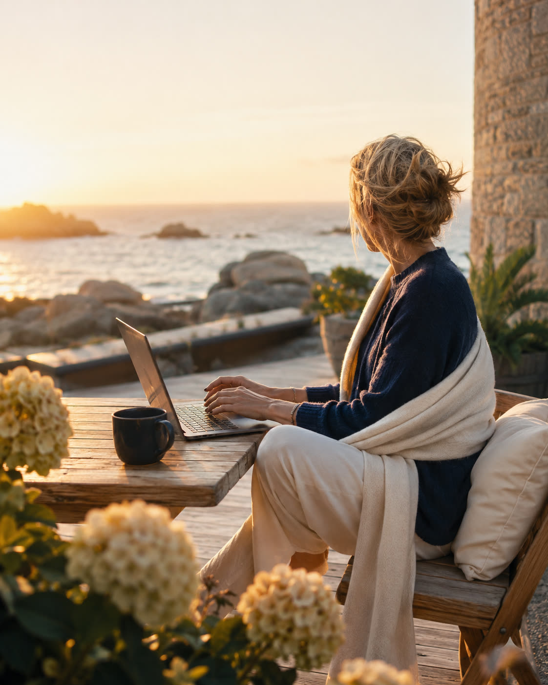 Conseillère travaillant sur son ordinateur face à la mer au coucher du soleil